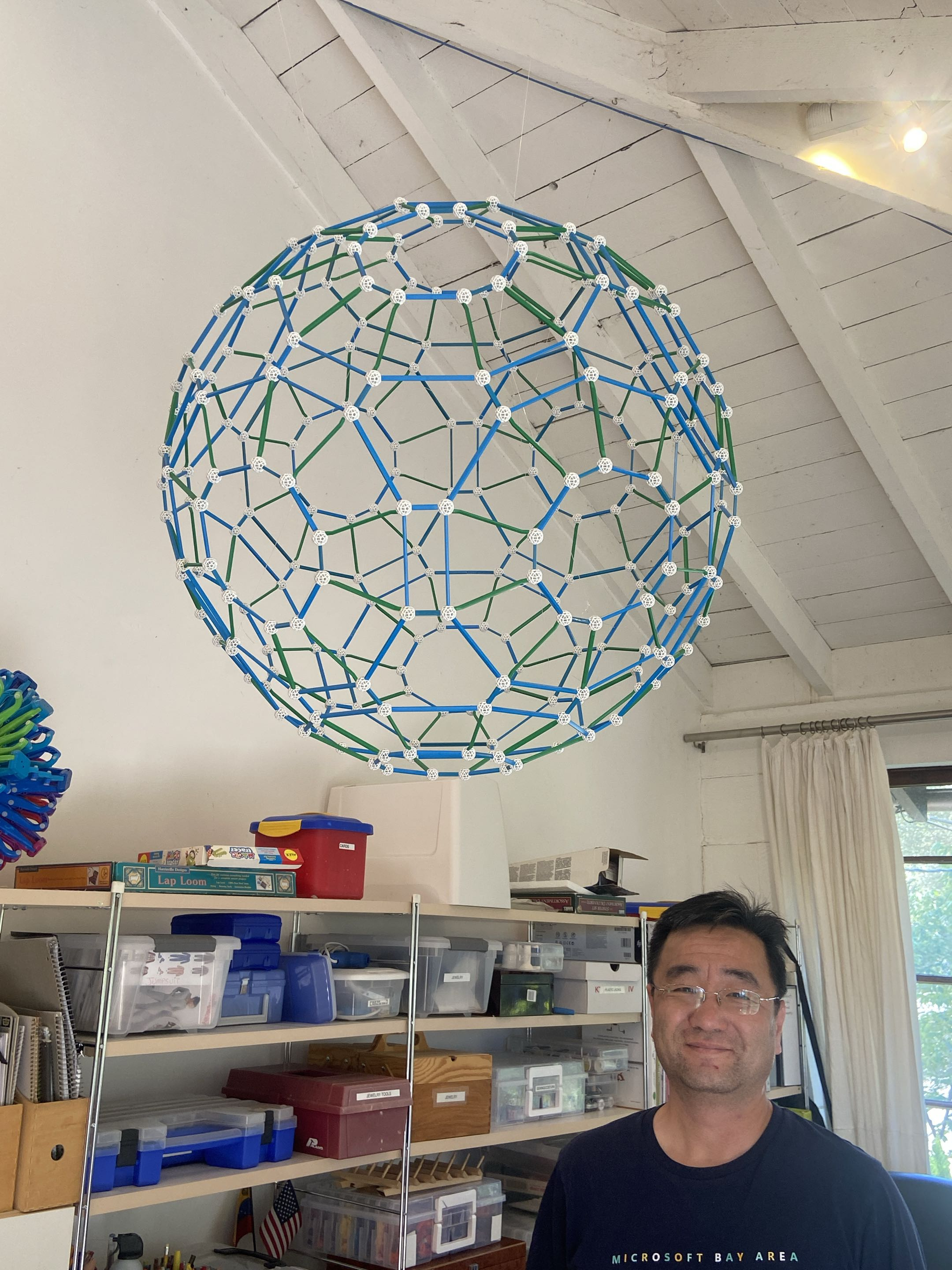 The blue-and-green 240-ball Zometool shell suspended from the ceiling